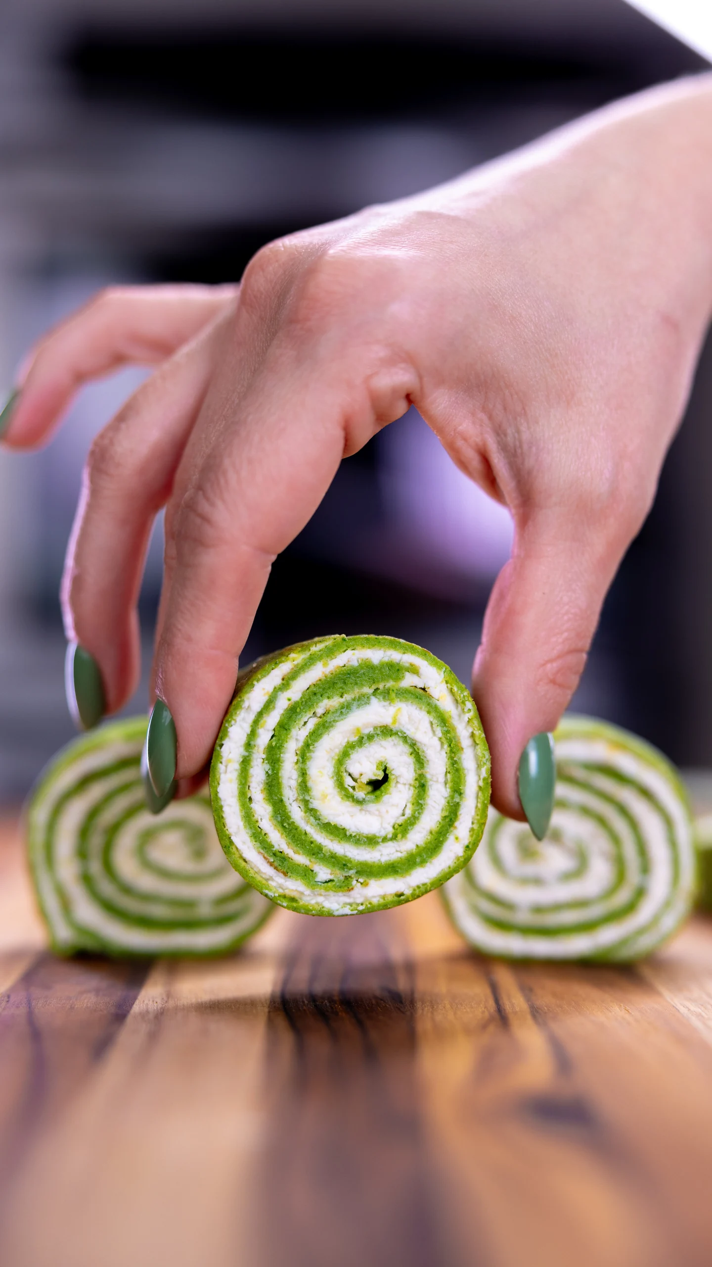 Green and white spiral rolls being sliced