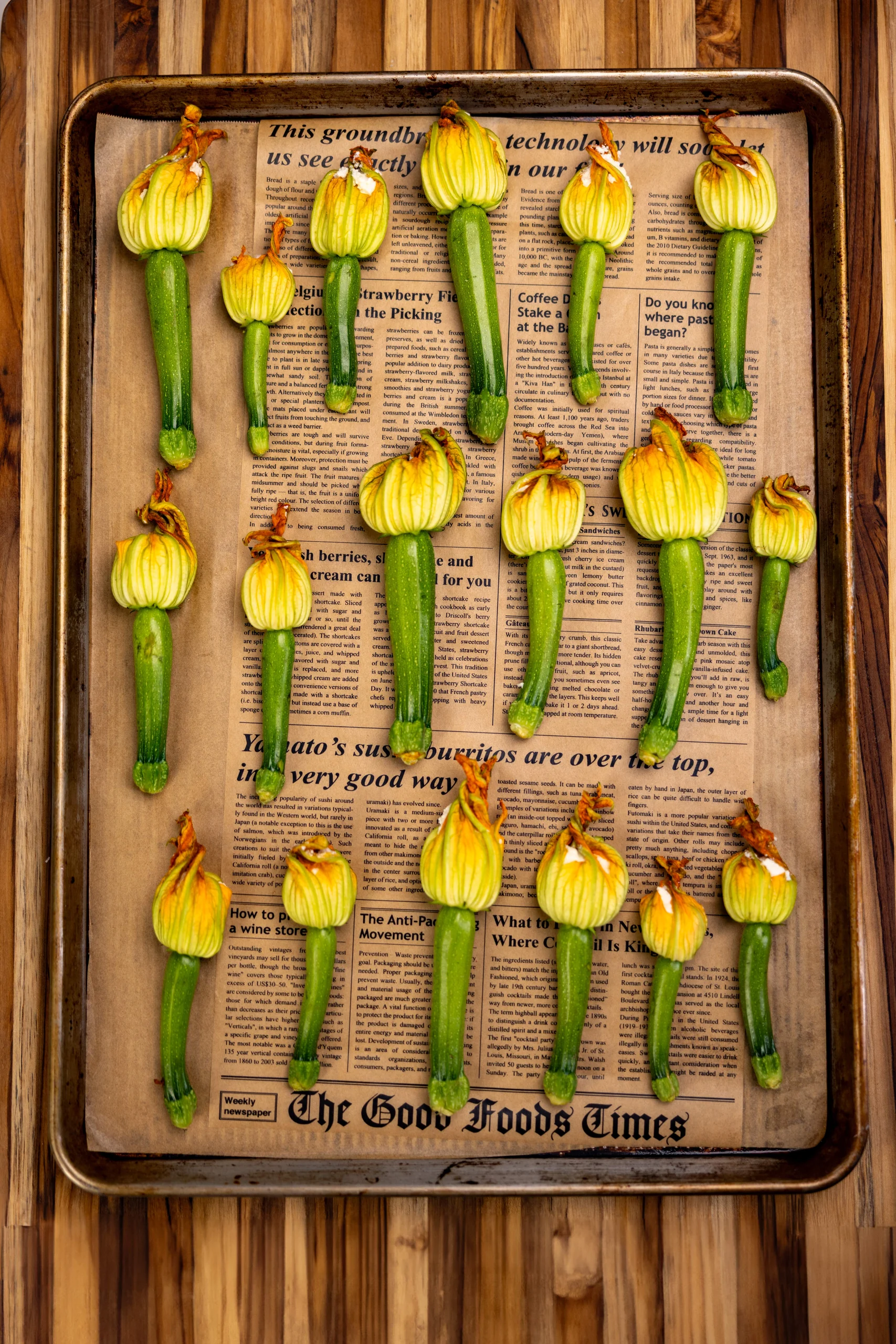 Zucchini with blossoms arranged on a baking tray